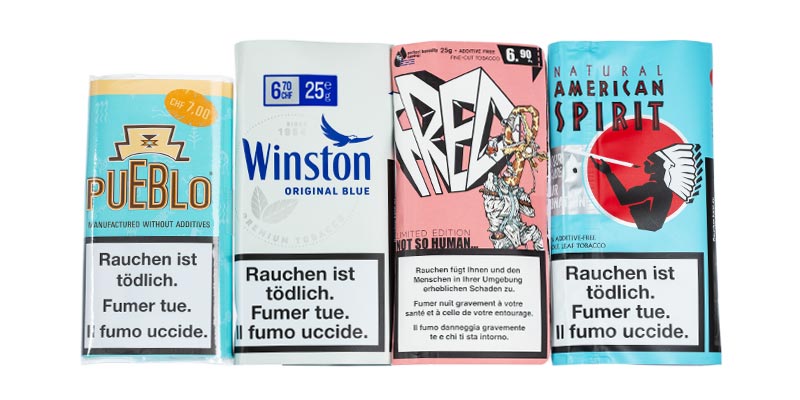 Vier Packungen Drehtabak: Pueblo Blau, Winston Blau, Fred Rose und American Spirit Blau, ohne Nikotinangaben auf den Verpackungen.